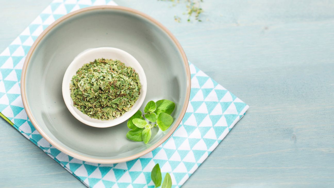 Getrockneter Oregano in einer weißen Schale mit frischen Oreganoblättern