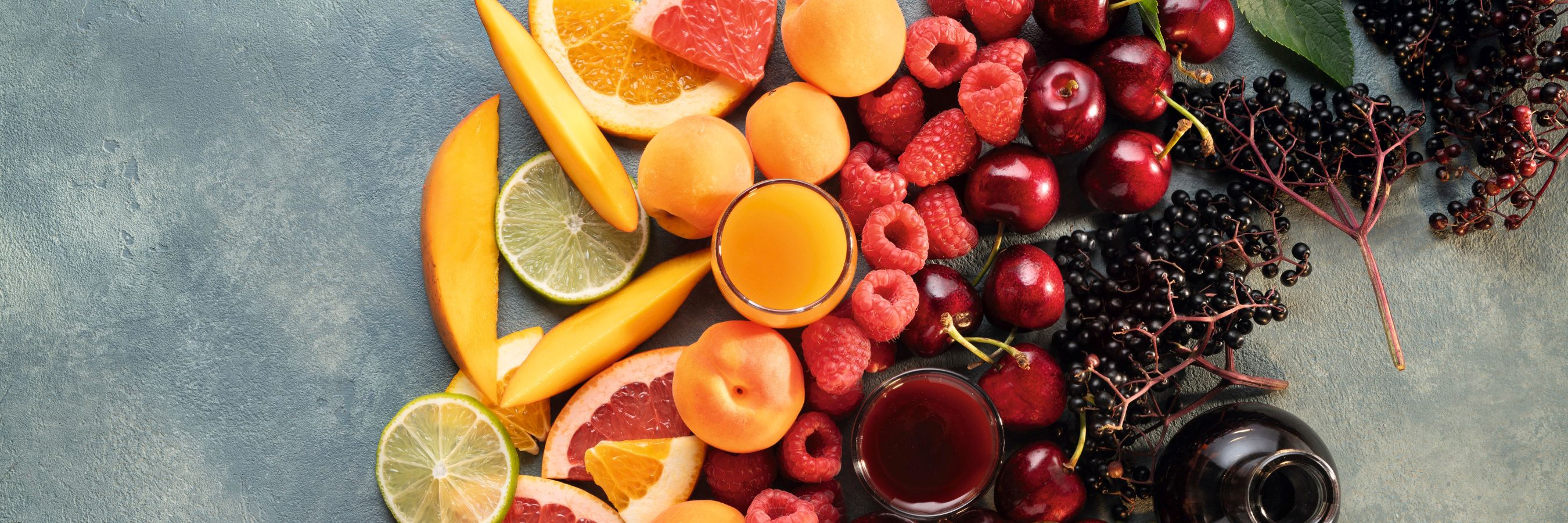 Farbsortierte Passionsfrüchte, Zitrusfrüchte, Mangos, Marillen, Himbeeren, Sauerkirschen und Holunder, kombiniert mit den intensiven WIBERG AcetoPlus Fruchtessigen.