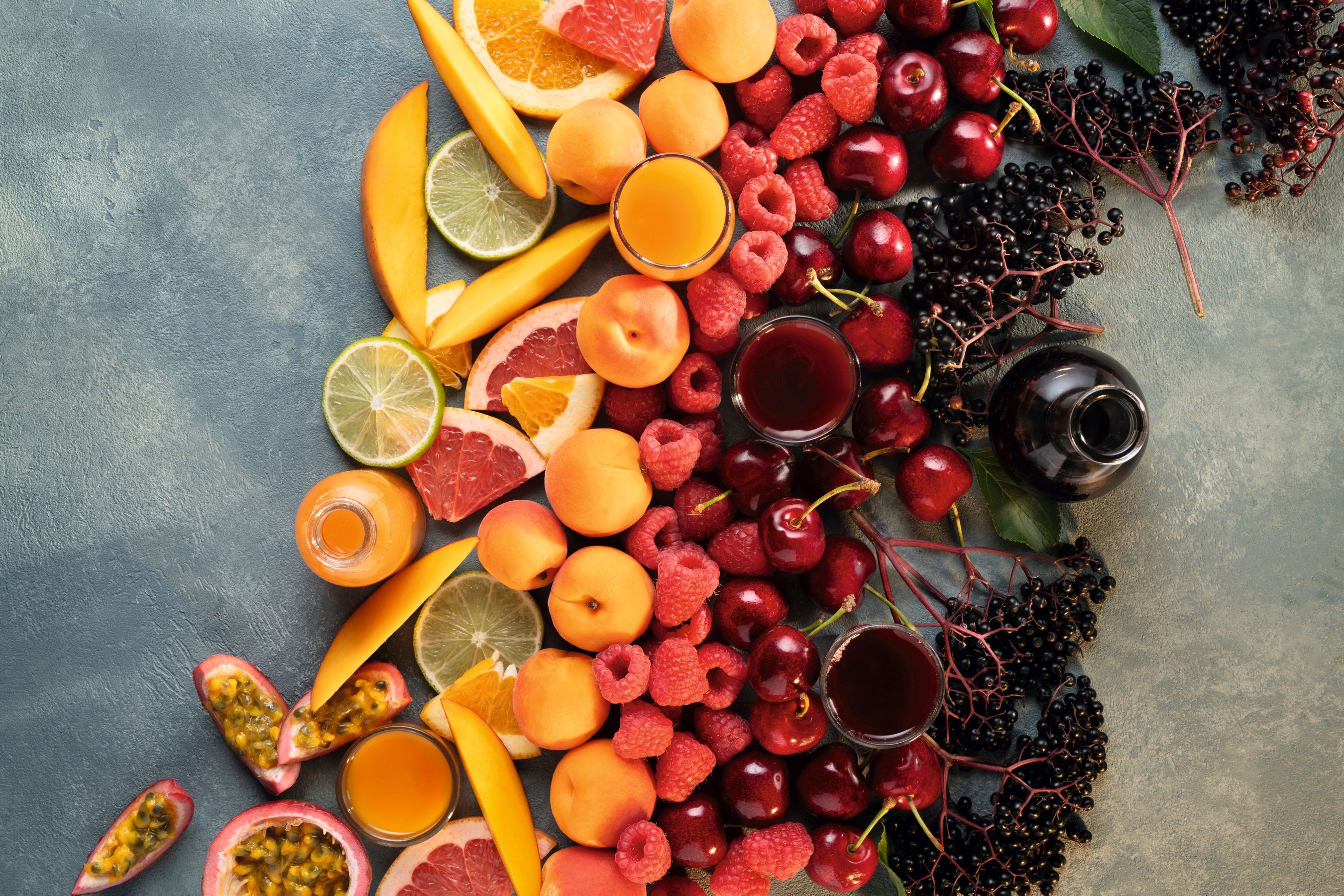 Farbsortierte Passionsfrüchte, Zitrusfrüchte, Mangos, Marillen, Himbeeren, Sauerkirschen und Holunder, kombiniert mit den intensiven WIBERG AcetoPlus Fruchtessigen.