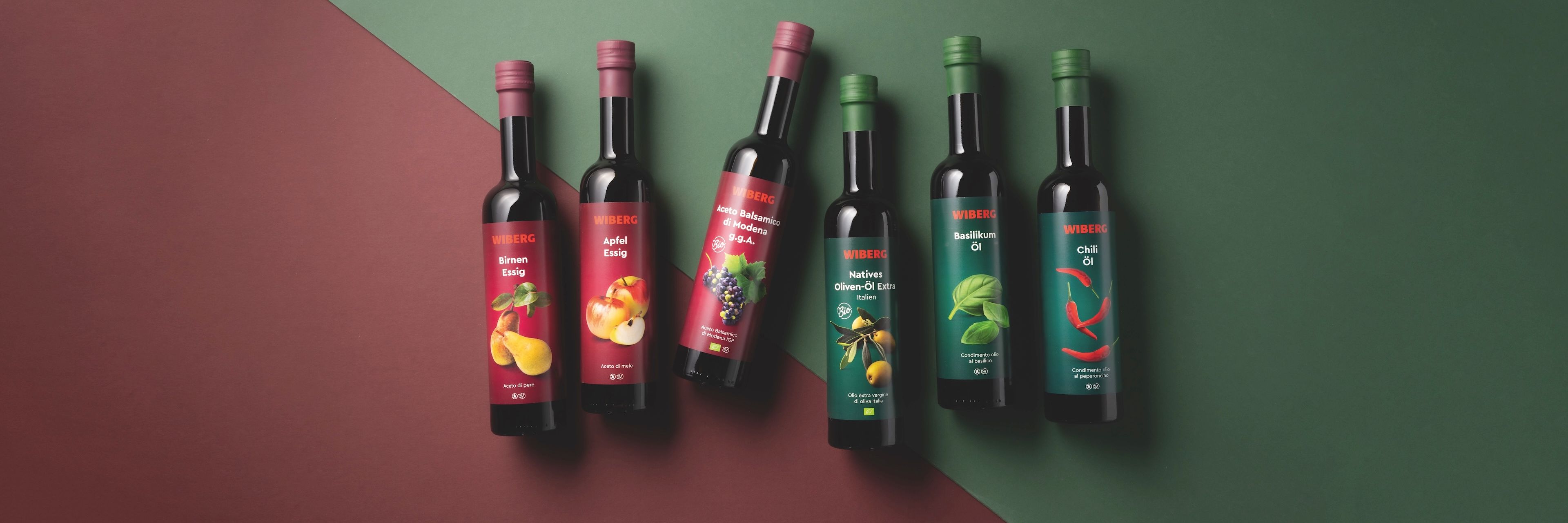 WIBERG Premium‑Essige und Öle mit neuem Etikettendesign auf zweifarbigem Hintergrund.