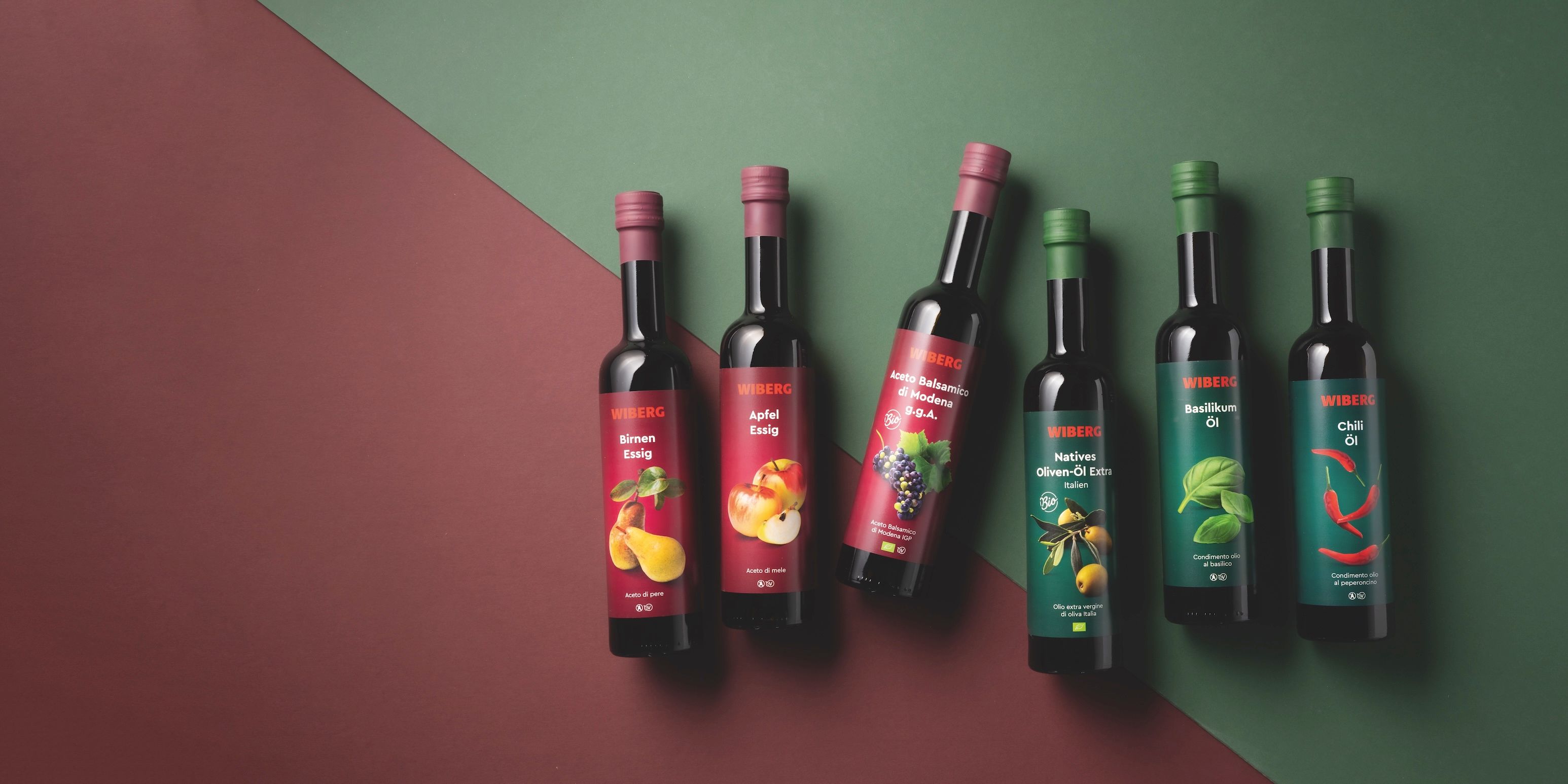 WIBERG Premium‑Essige und Öle mit neuem Etikettendesign auf zweifarbigem Hintergrund.