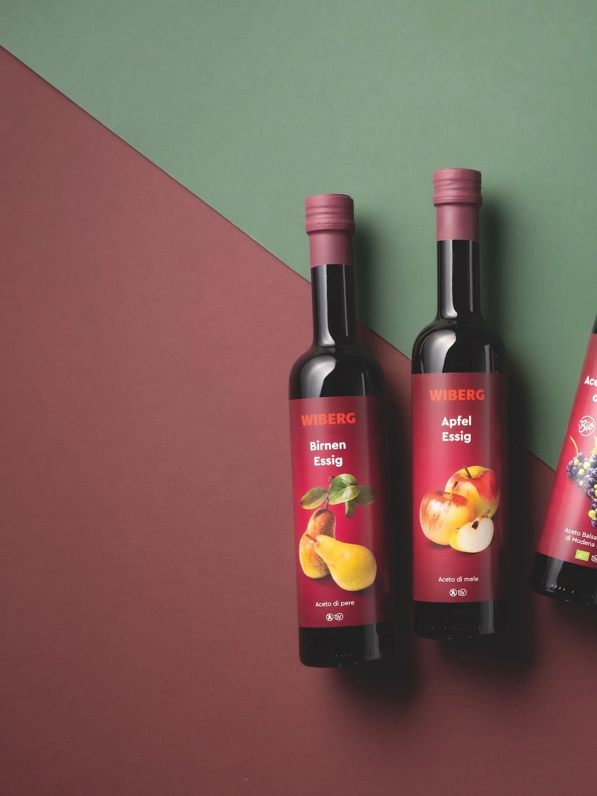 WIBERG Premium‑Essige und Öle mit neuem Etikettendesign auf zweifarbigem Hintergrund.
