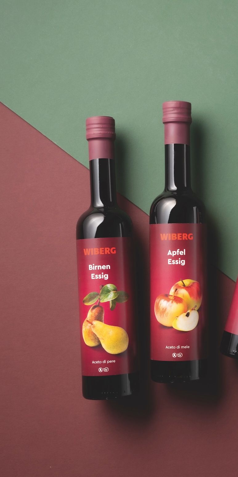 WIBERG Premium‑Essige und Öle mit neuem Etikettendesign auf zweifarbigem Hintergrund.