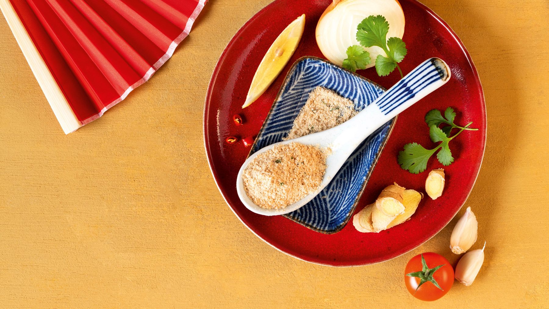Asiatischer Teller mit Keramiklöffel voller WIBERG Miso-Suppenpulver, umgeben von frischen Zutaten wie Pilzen, Ingwer, Chili, Knoblauch und Koriander.
