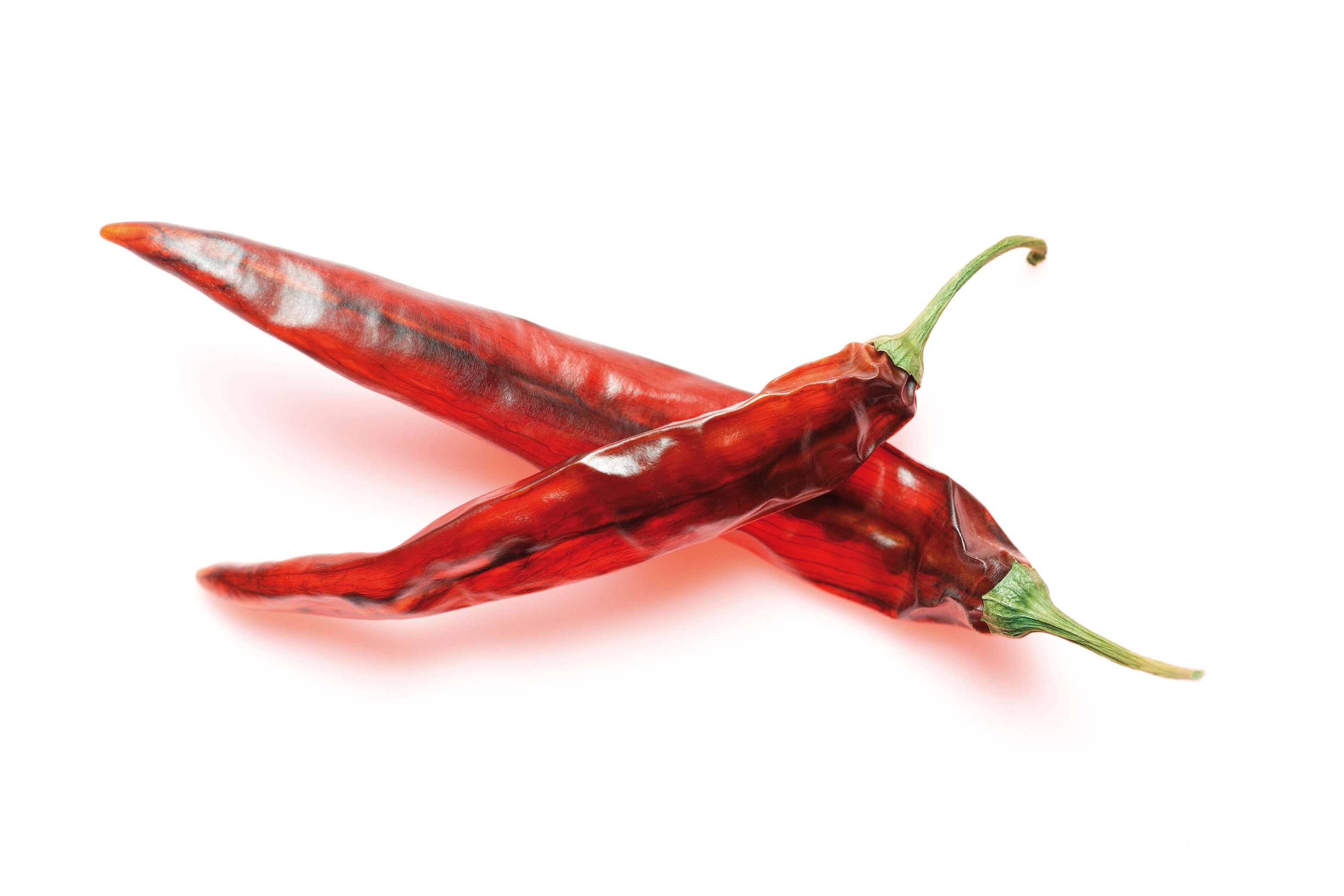 Fein geschnittene rote Chilischoten vor weißem Hintergrund