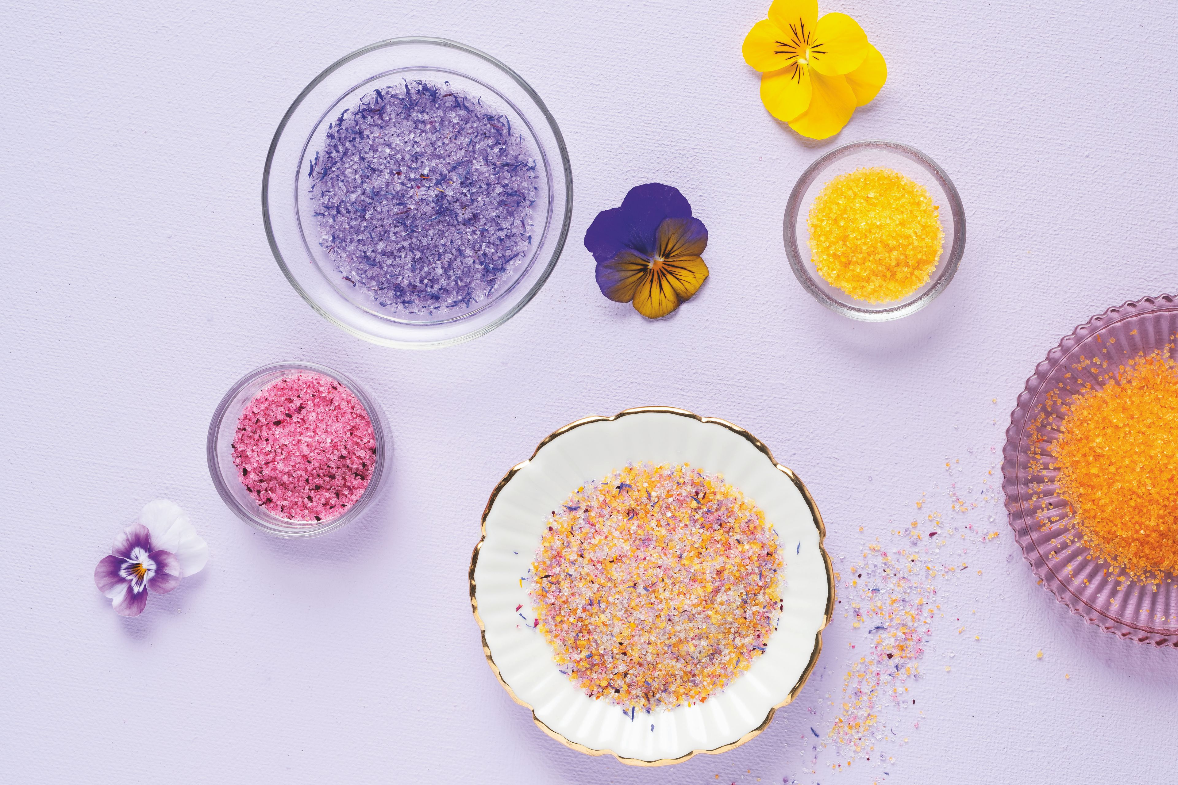  WIBERG Blütenzucker bunt auf helllila Hintergrund: farbenfrohe Blütenzucker-Mischung aus Tagetes-, Rosen-, Kornblumen- und Sonnenblumenblüten.