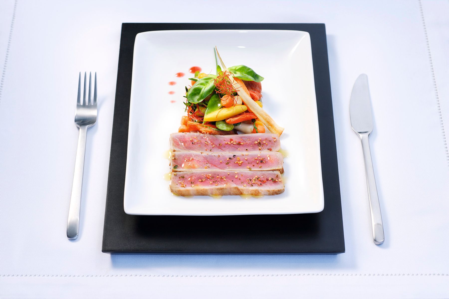 Kurz gegrillter Thunfisch auf mediterranem Gemüsesalat, garniert mit Basilikum und WIBERG Spicy Chili Würzsauce – verfeinert mit WIBERG Louisiana Style.