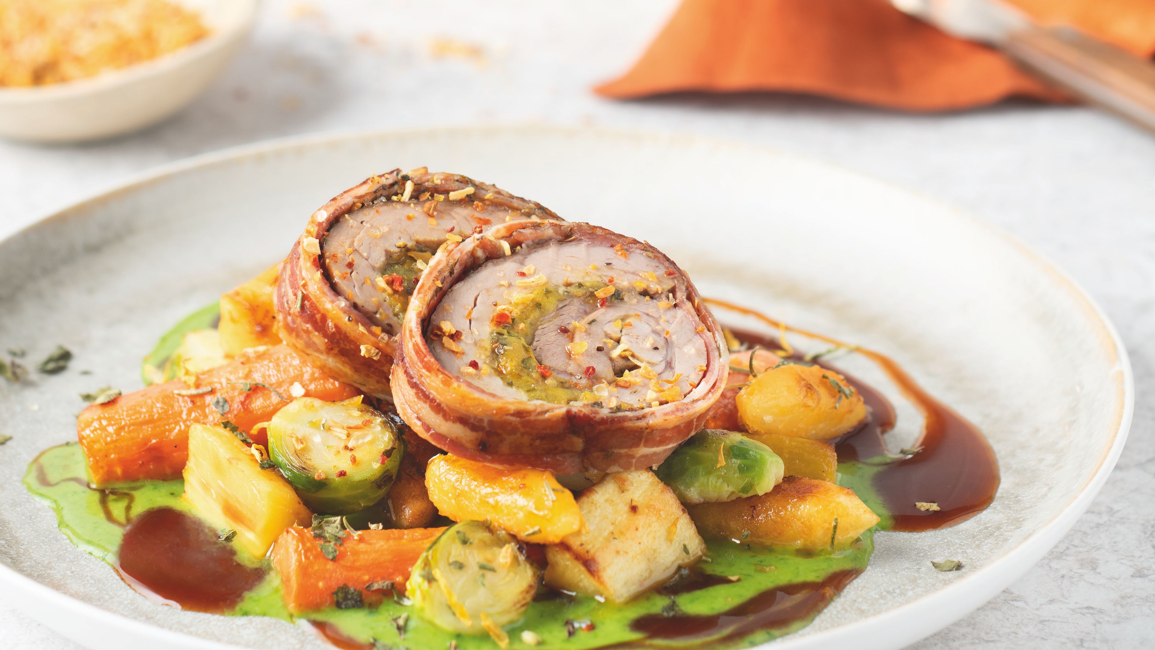 WIBERG Rezept: Putenrollbraten mit Gnocchi, Gemüse und Kräutersauce – verfeinert mit Exquisite Golden BBQ, angerichtet auf Teller in heller Küchenumgebung.