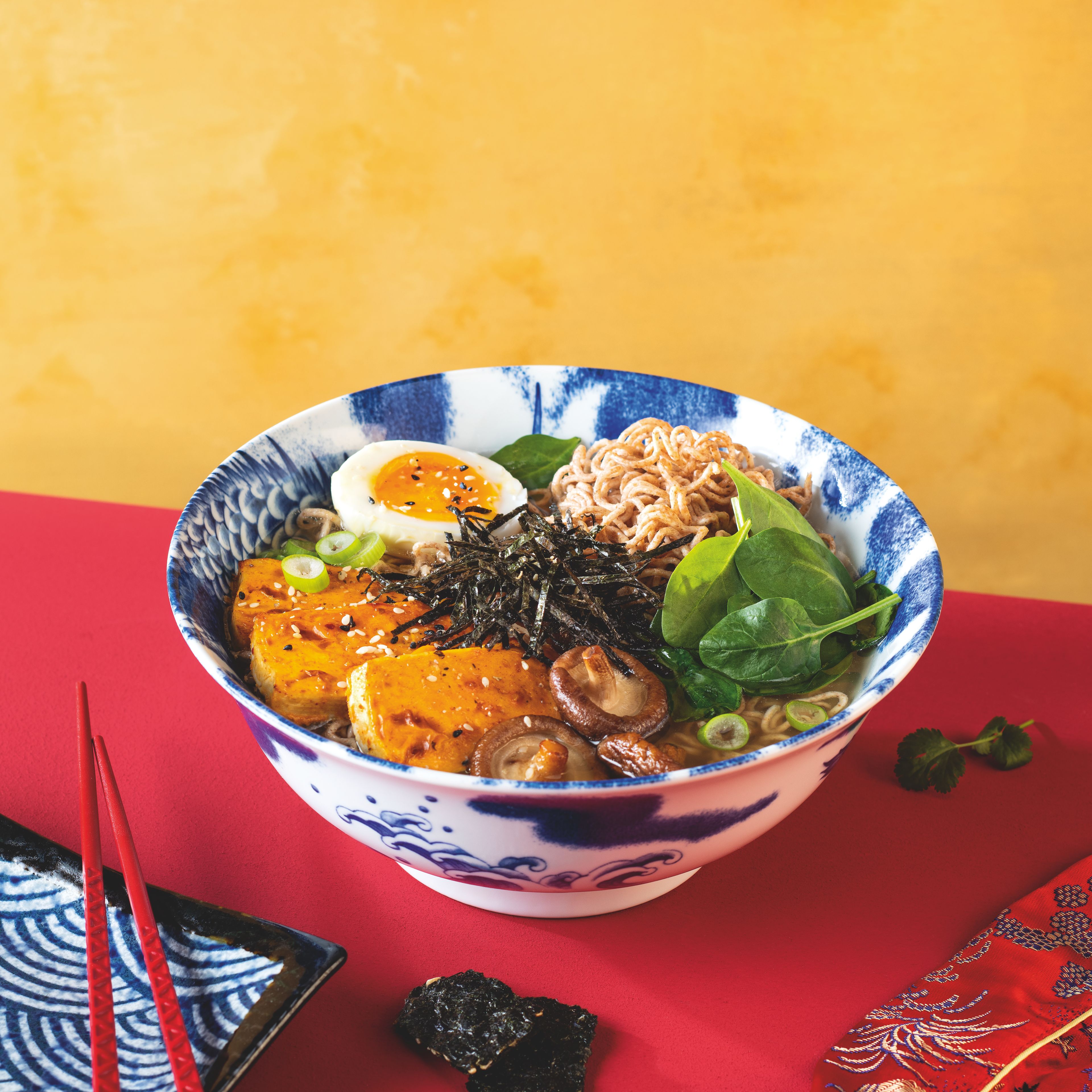 Asiatische Suppenschüssel mit Miso‑Ramen auf dezent asiatisch dekorierter Tafel – authentische Rezeptinspiration mit WIBERG Miso‑Suppe.