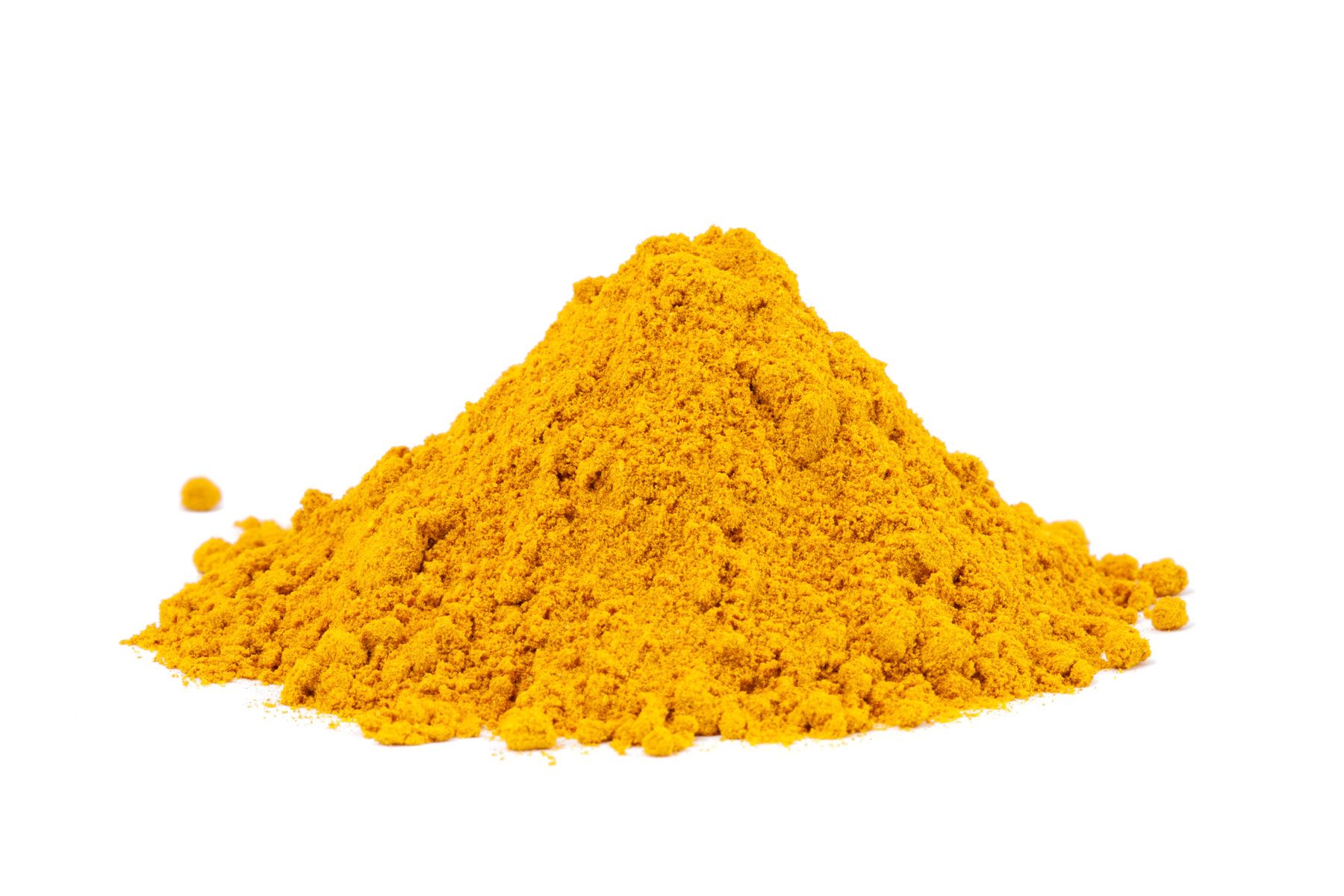Gelbes Currypulver als kleiner Haufen vor weißem Hintergrund